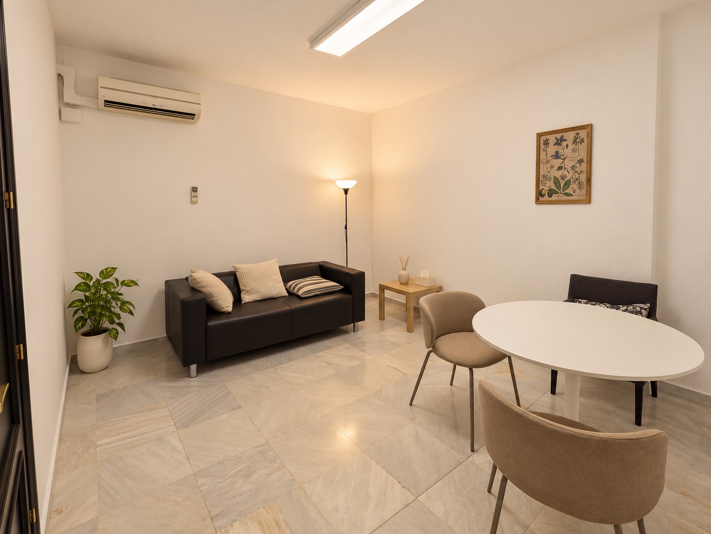 Vista de una sala de psicoterapia con sofá, butacas y mesa